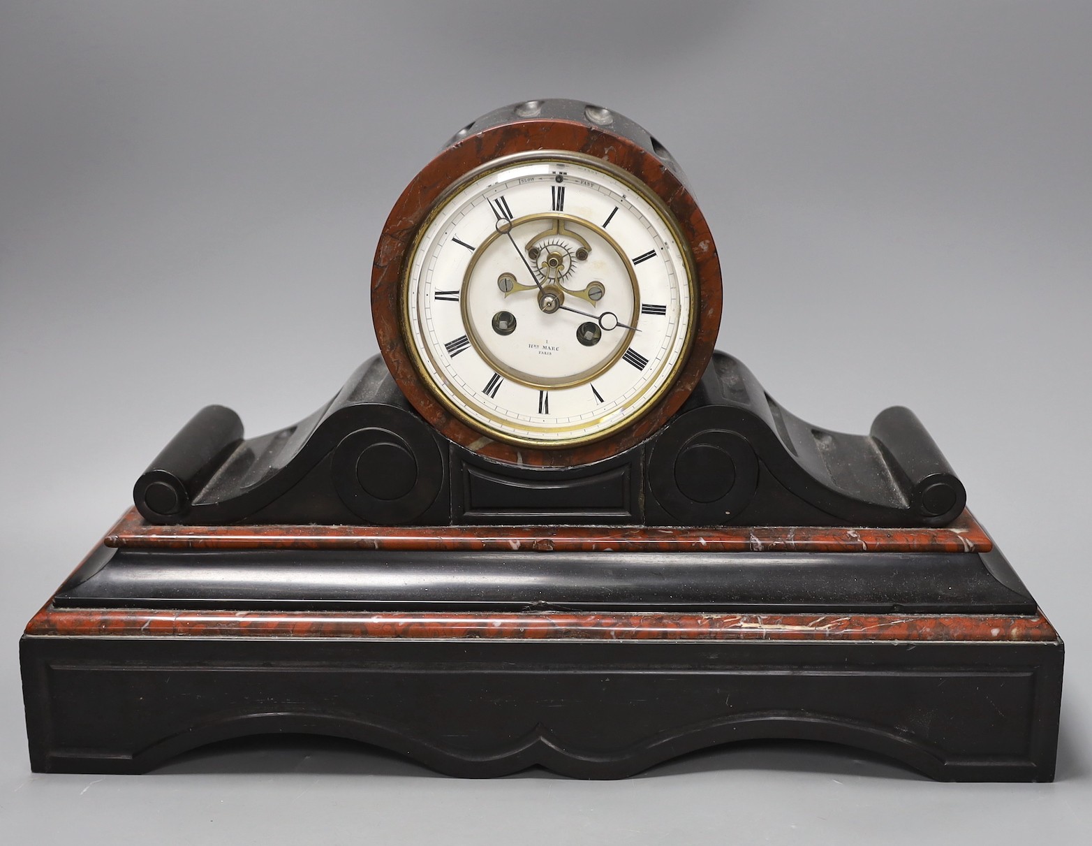 A French black slate and rouge marble mantel clock by Henry Marc, with key and pendulum, 28.5cm tall
